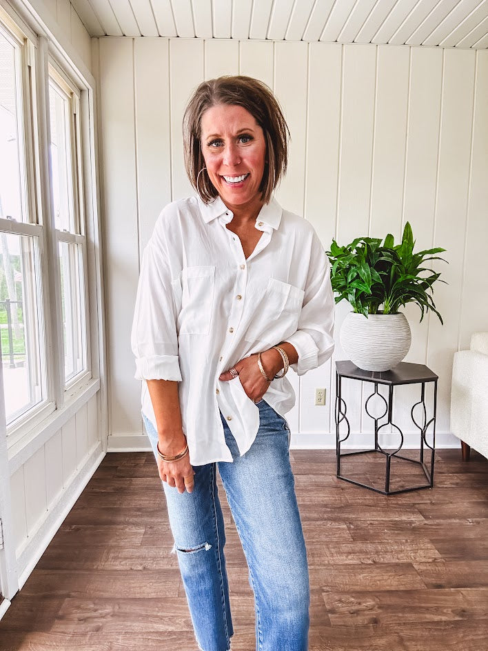 White, nearly sheer long sleeved button down with two front pockets, faux wooden buttons down the front and an oversized fit.