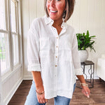 White, nearly sheer long sleeved button down with two front pockets, faux wooden buttons down the front and an oversized fit.