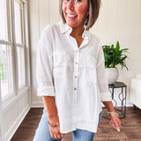 White, nearly sheer long sleeved button down with two front pockets, faux wooden buttons down the front and an oversized fit.