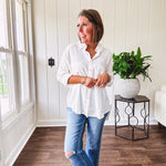 White, nearly sheer long sleeved button down with two front pockets, faux wooden buttons down the front and an oversized fit.