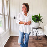 White, nearly sheer long sleeved button down with two front pockets, faux wooden buttons down the front and an oversized fit.