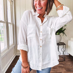 White, nearly sheer long sleeved button down with two front pockets, faux wooden buttons down the front and an oversized fit.