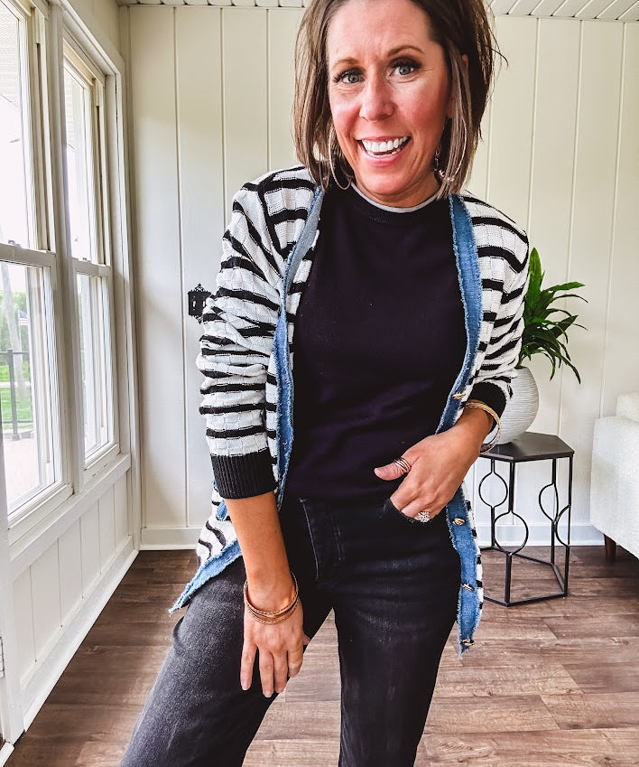 Lightweight black and white striped cardigan with checkered texture, denim raw edge trim at the placket and on the two faux front pockets with gold buttons.