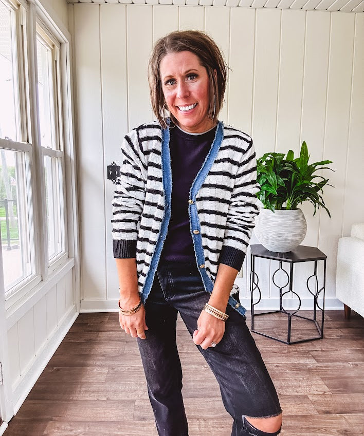 Lightweight black and white striped cardigan with checkered texture, denim raw edge trim at the placket and on the two faux front pockets with gold buttons.