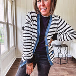 Lightweight black and white striped cardigan with checkered texture, denim raw edge trim at the placket and on the two faux front pockets with gold buttons.