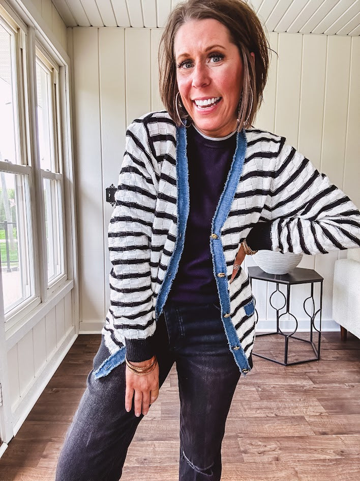 Lightweight black and white striped cardigan with checkered texture, denim raw edge trim at the placket and on the two faux front pockets with gold buttons.