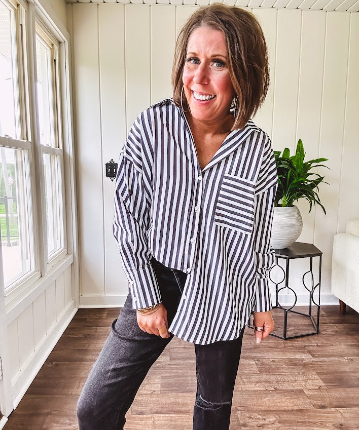 Oversized muted black and white striped button down long sleeved top with front pocket and white buttons.