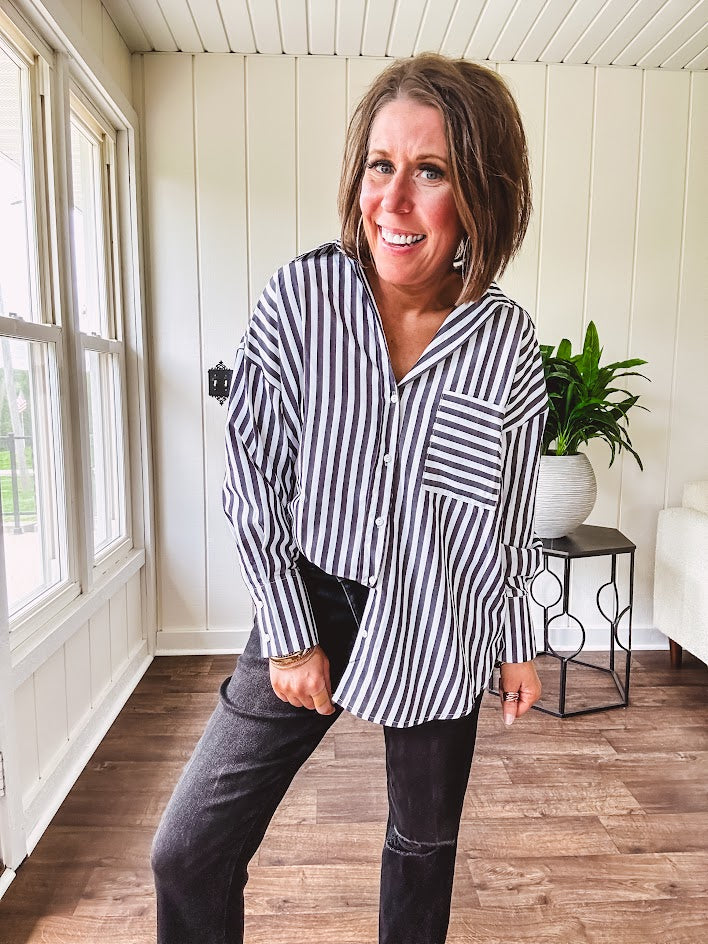 Oversized muted black and white striped button down long sleeved top with front pocket and white buttons.