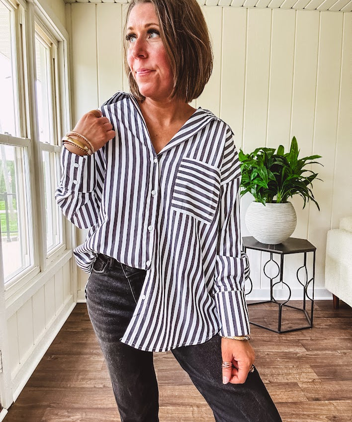 Oversized muted black and white striped button down long sleeved top with front pocket and white buttons.