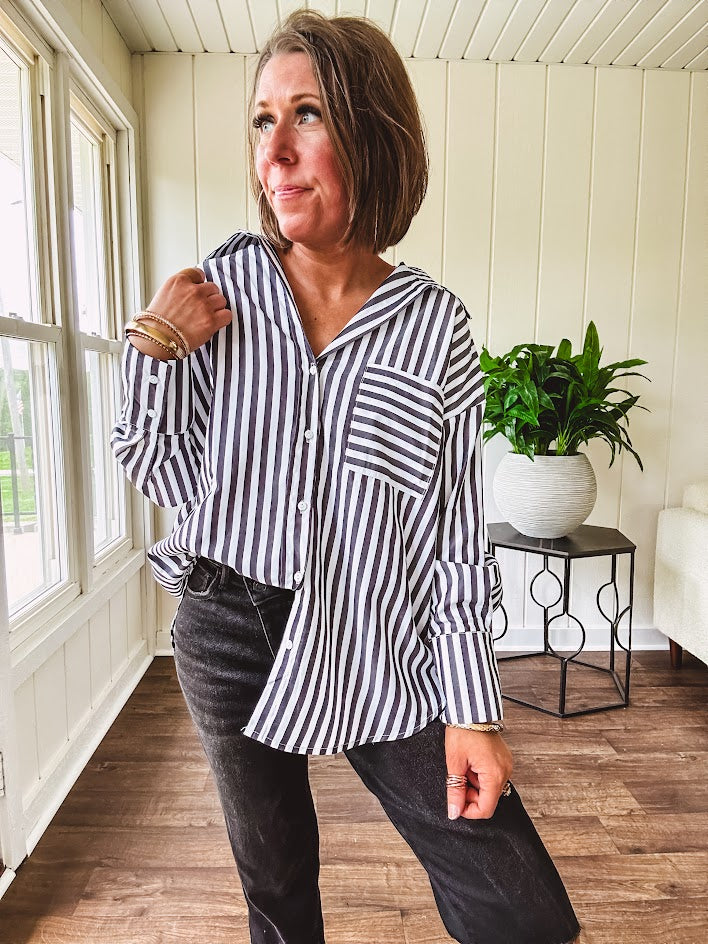 Oversized muted black and white striped button down long sleeved top with front pocket and white buttons.