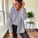 Oversized muted black and white striped button down long sleeved top with front pocket and white buttons.