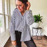 Oversized muted black and white striped button down long sleeved top with front pocket and white buttons.