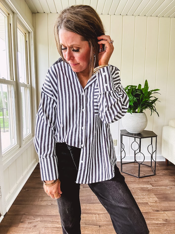 Oversized muted black and white striped button down long sleeved top with front pocket and white buttons.