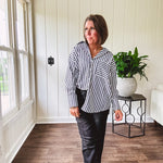 Oversized muted black and white striped button down long sleeved top with front pocket and white buttons.