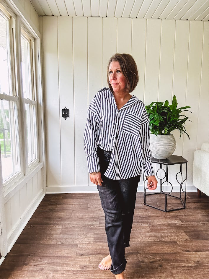 Oversized muted black and white striped button down long sleeved top with front pocket and white buttons.