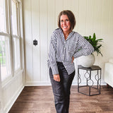 Oversized muted black and white striped button down long sleeved top with front pocket and white buttons.