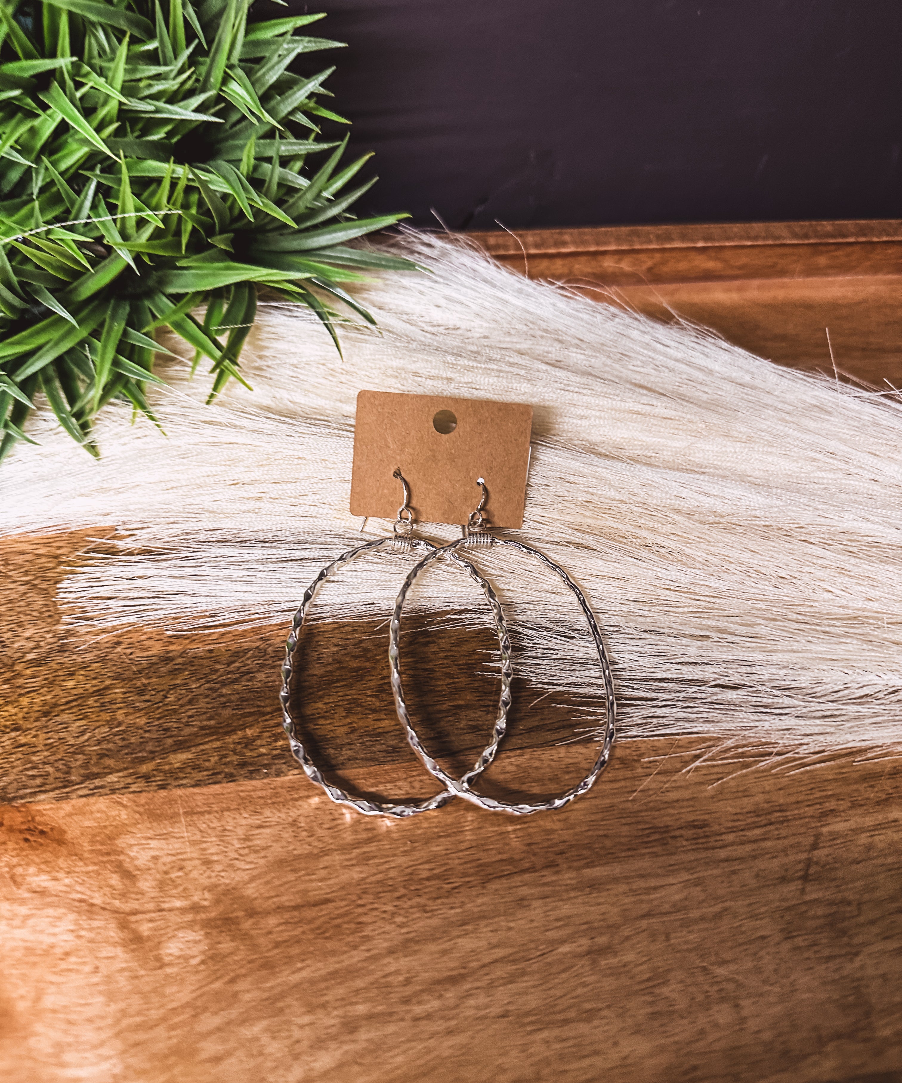 Large hammered sterling silver oval earrings on a shepherd's hook back.