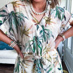 Lightweight and breezy set including a nearly sheer short sleeved tie front V neck top with cuffs at the sleeves and matching fully lined flowy skirt with elastic waist with flat front and pockets in beige with Earth toned tropical pattern.