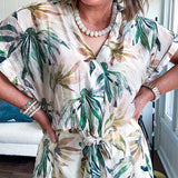 Lightweight and breezy set including a nearly sheer short sleeved tie front V neck top with cuffs at the sleeves and matching fully lined flowy skirt with elastic waist with flat front and pockets in beige with Earth toned tropical pattern.