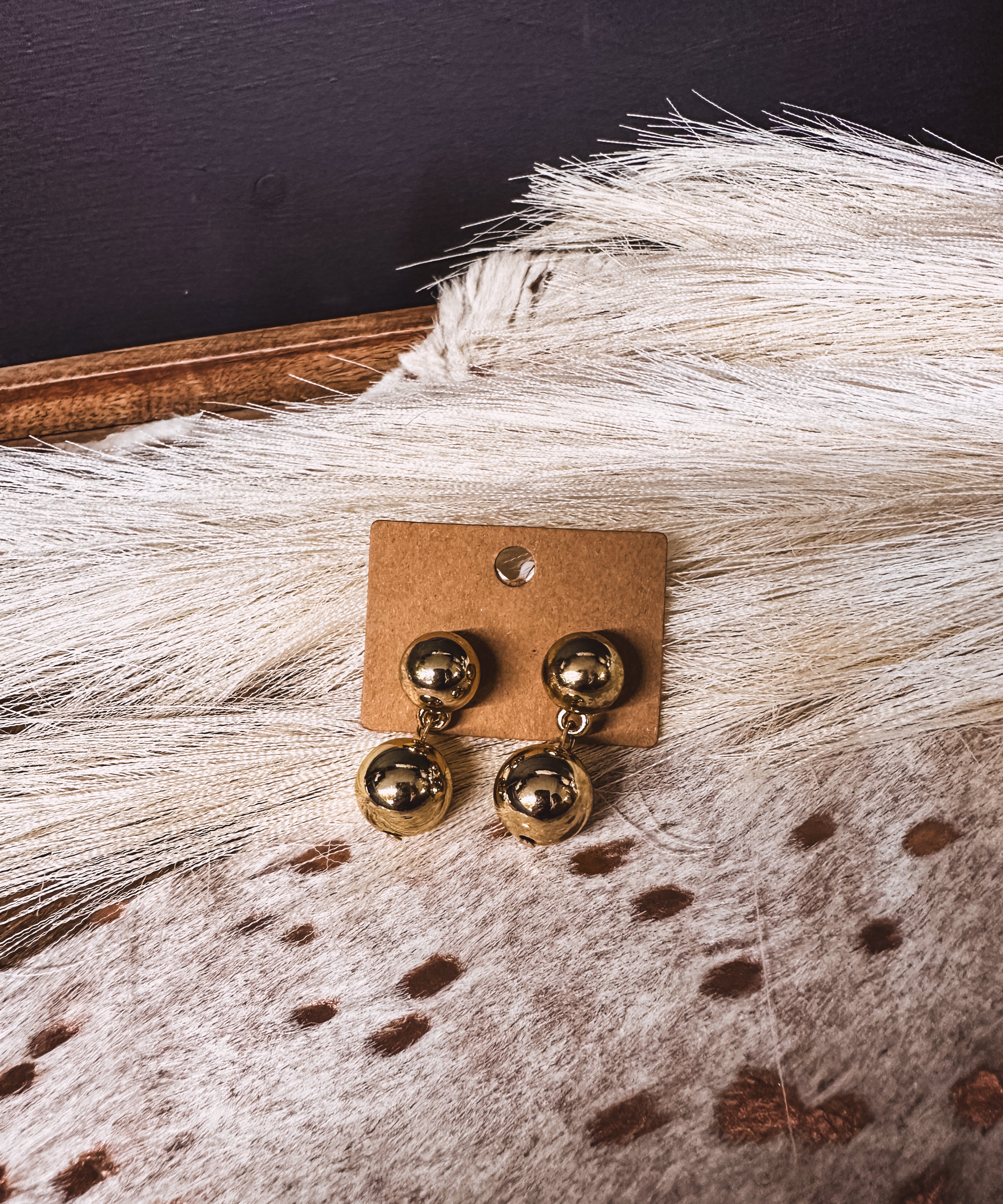 Gold ball post back earrings with gold ball connected by chain link on a post back