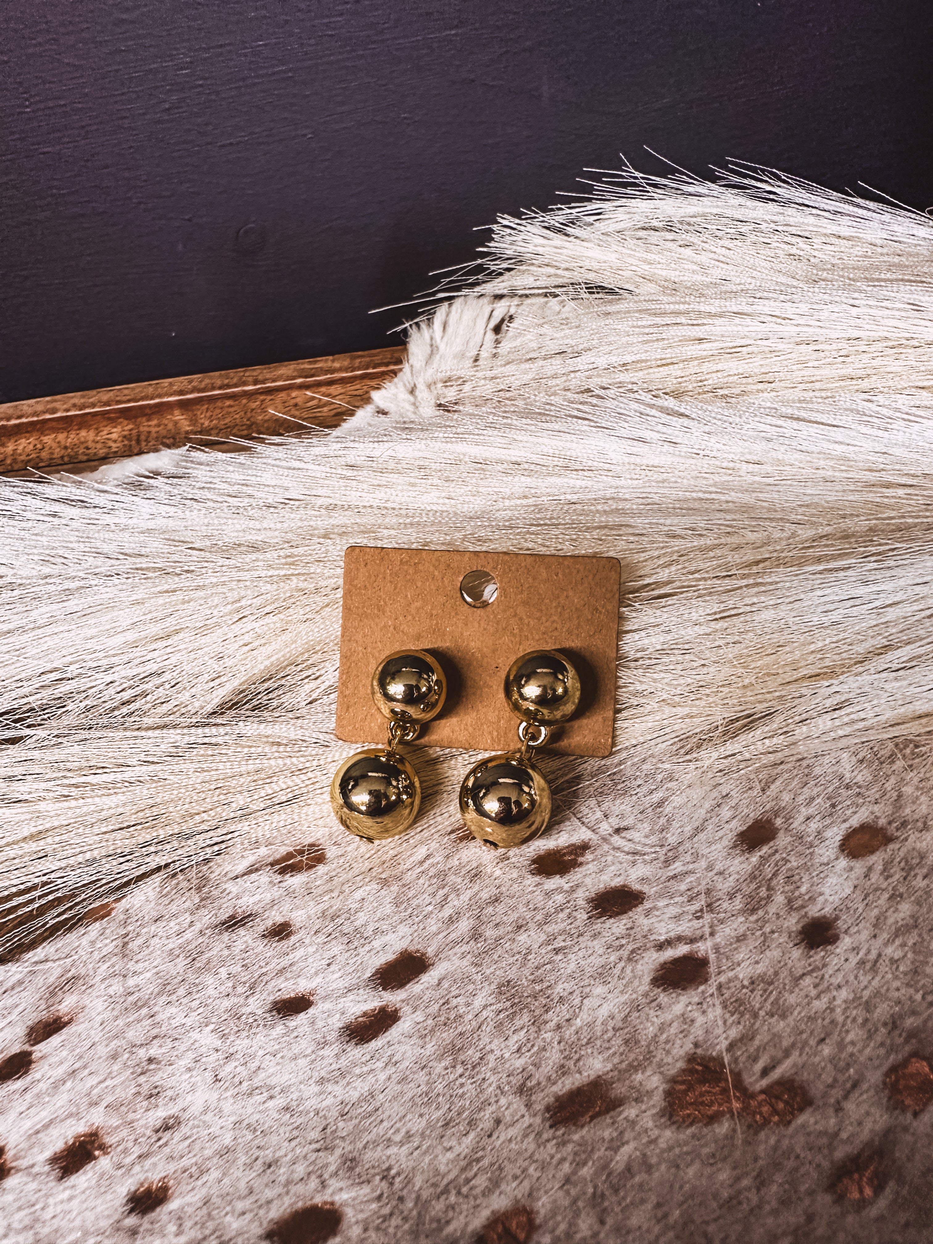 Gold ball post back earrings with gold ball connected by chain link on a post back