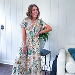 Lightweight and breezy set including a nearly sheer short sleeved tie front V neck top with cuffs at the sleeves and matching fully lined flowy skirt with elastic waist with flat front and pockets in beige with Earth toned tropical pattern.