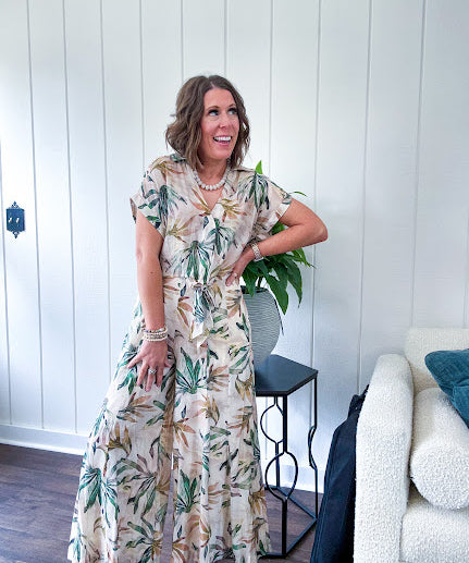 Lightweight and breezy set including a nearly sheer short sleeved tie front V neck top with cuffs at the sleeves and matching fully lined flowy skirt with elastic waist with flat front and pockets in beige with Earth toned tropical pattern.