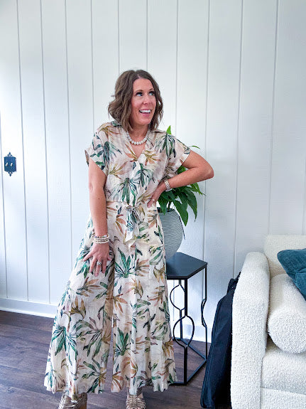 Lightweight and breezy set including a nearly sheer short sleeved tie front V neck top with cuffs at the sleeves and matching fully lined flowy skirt with elastic waist with flat front and pockets in beige with Earth toned tropical pattern.