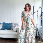 Lightweight and breezy set including a nearly sheer short sleeved tie front V neck top with cuffs at the sleeves and matching fully lined flowy skirt with elastic waist with flat front and pockets in beige with Earth toned tropical pattern.