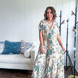 Lightweight and breezy set including a nearly sheer short sleeved tie front V neck top with cuffs at the sleeves and matching fully lined flowy skirt with elastic waist with flat front and pockets in beige with Earth toned tropical pattern.