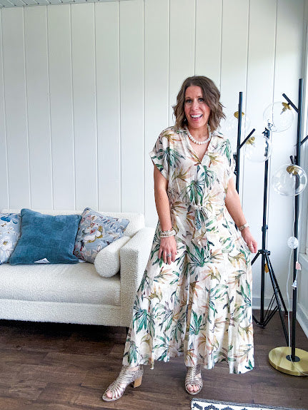 Lightweight and breezy set including a nearly sheer short sleeved tie front V neck top with cuffs at the sleeves and matching fully lined flowy skirt with elastic waist with flat front and pockets in beige with Earth toned tropical pattern.