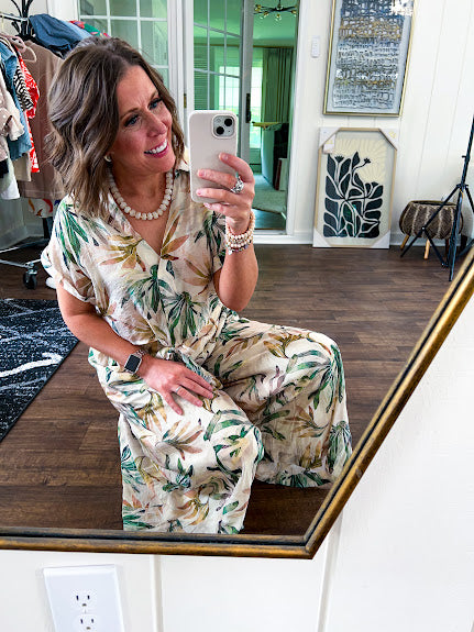 Lightweight and breezy set including a nearly sheer short sleeved tie front V neck top with cuffs at the sleeves and matching fully lined flowy skirt with elastic waist with flat front and pockets in beige with Earth toned tropical pattern.