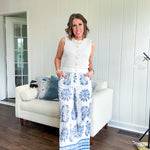 White cotton wide leg pants with denim blue sea inspired print, eyelet cutouts throughout, elastic drawstring waist and pockets with shorts lining.