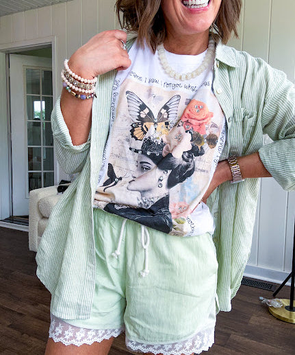 Cream cotton tee with vintage inspired graphic of Victorian woman, butterflies, flowers and rhinestones with scatterbrained phrases around the edges.