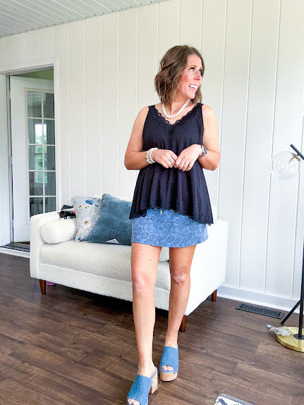 Lightweight ribbed black tank with lace trim at the V neck on the front and back with lace strip across the back and lace trim at the flowy hem.