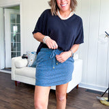 Soft knit denim blue skort with shorts lining, elastic waist and pockets with paisley print throughout.