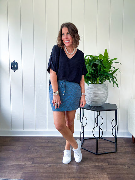 Soft knit denim blue skort with shorts lining, elastic waist and pockets with paisley print throughout.