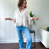 Thin, lightweight beige button down cropped jacket with collar, ruffled hem and ruffle at the cuffs with texture.