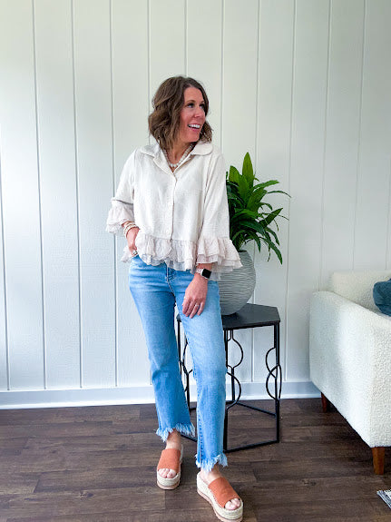 Thin, lightweight beige button down cropped jacket with collar, ruffled hem and ruffle at the cuffs with texture.