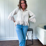 Thin, lightweight beige button down cropped jacket with collar, ruffled hem and ruffle at the cuffs with texture.