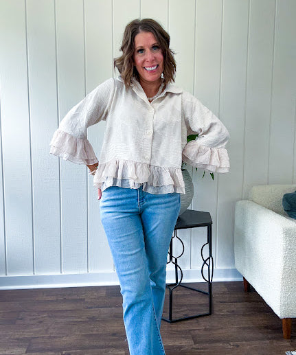 Thin, lightweight beige button down cropped jacket with collar, ruffled hem and ruffle at the cuffs with texture.