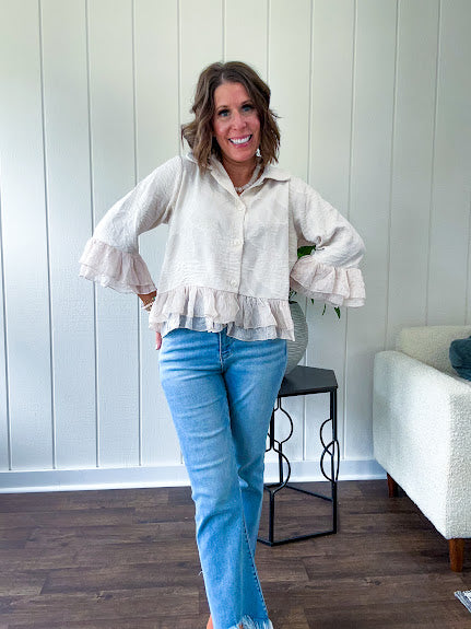 Thin, lightweight beige button down cropped jacket with collar, ruffled hem and ruffle at the cuffs with texture.