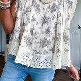 Thin, lightweight oversized cream button down sleeveless blouse with vintage inspired florals throughout and lace inserts and trim at the sleeves and hem.