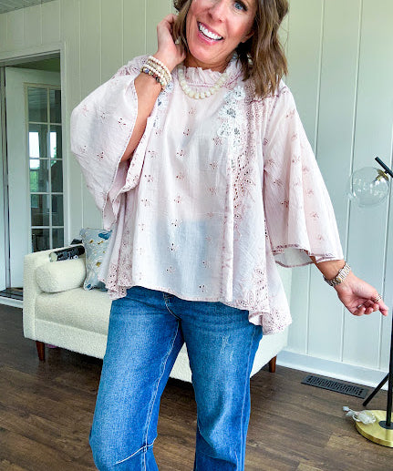 Cotton nearly sheer blouse with 3/4 sleeves, floral beading and eyelet detail throughout, ruffled neckline and flowy hem.