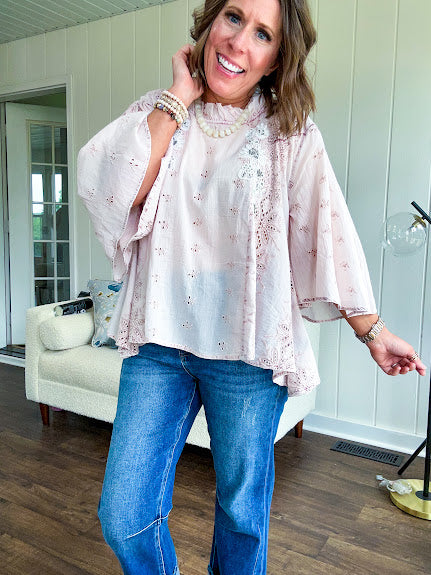 Cotton nearly sheer blouse with 3/4 sleeves, floral beading and eyelet detail throughout, ruffled neckline and flowy hem.