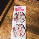 Two cream and red floral/bow neoprene car coasters.