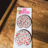 Two cream and red floral/bow neoprene car coasters.