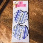 Two blue and white floral and stripe neoprene car coasters.