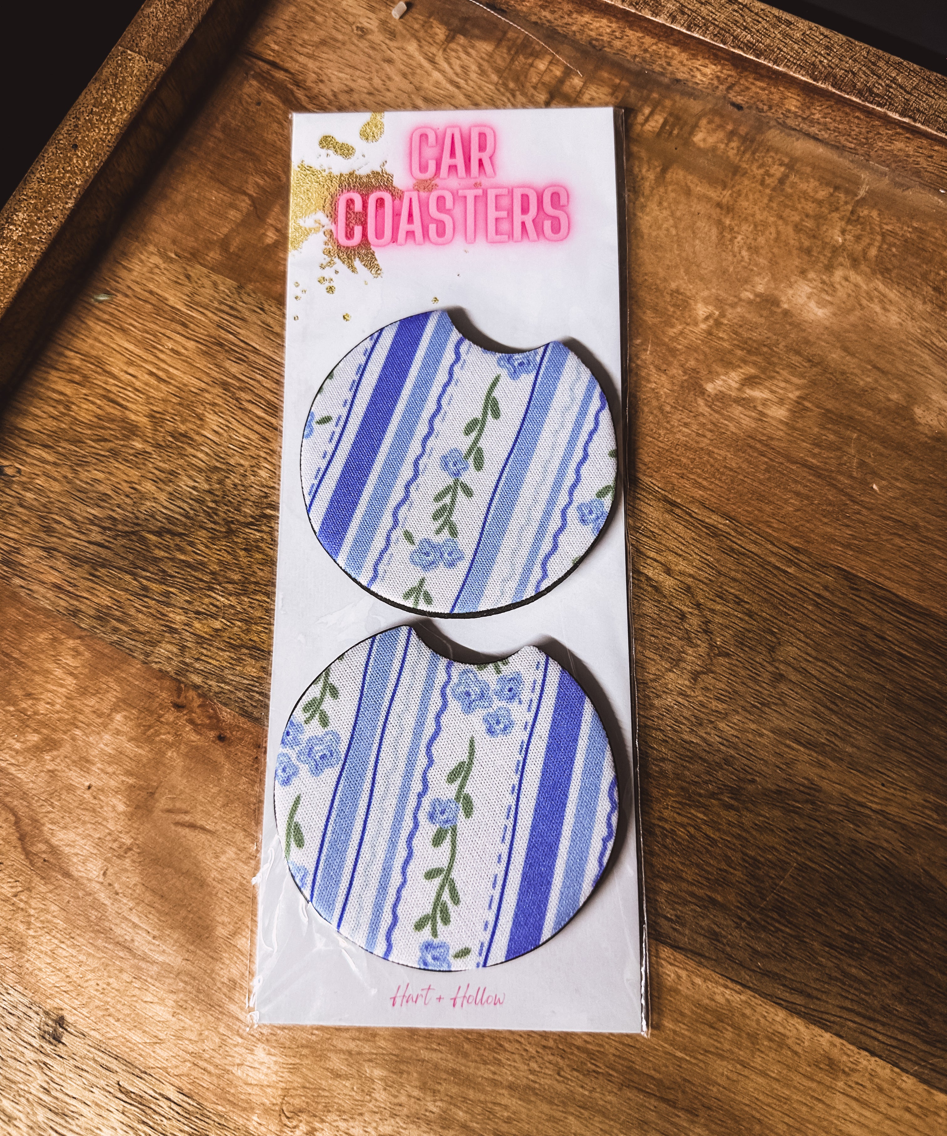 Two blue and white floral and stripe neoprene car coasters.