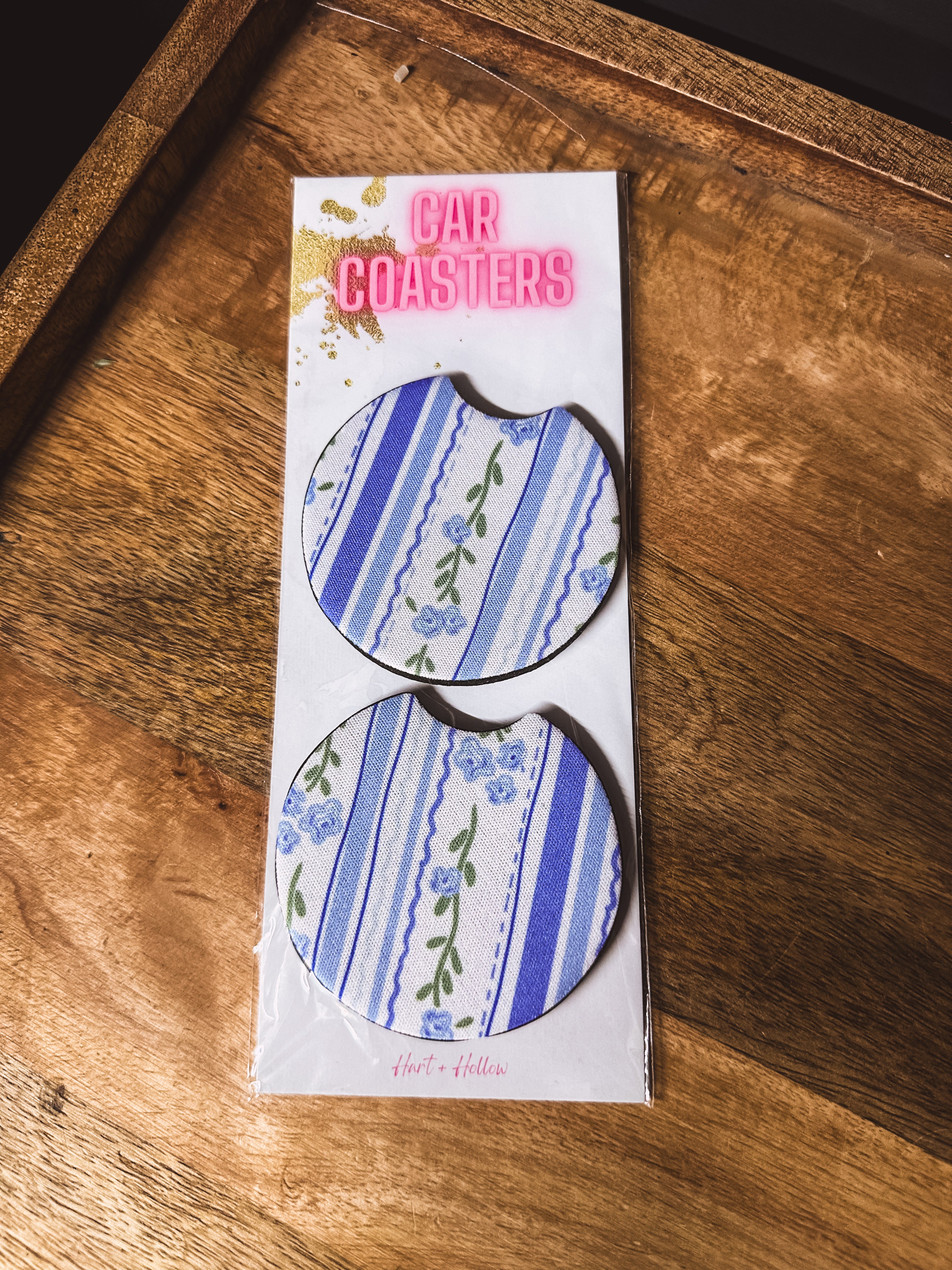 Two blue and white floral and stripe neoprene car coasters.